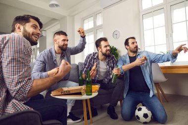 Bira ve pizza içip futbol izleyen bir grup heyecanlı adam.