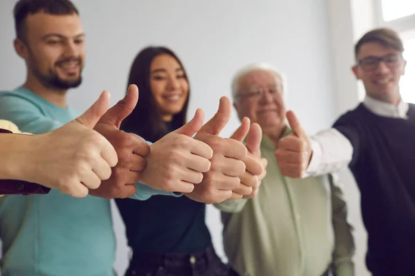 Grupo de pessoas diversas positivas comemorando o trabalho em equipe bem sucedido e mostrando o polegar para cima — Fotografia de Stock