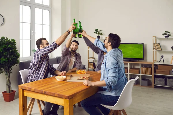 Groep jonge vrienden die bier drinken, pizza eten en samen plezier hebben — Stockfoto