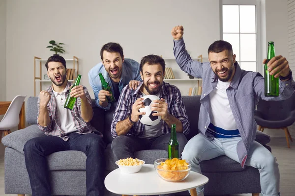 Vrienden zitten op de bank, kijken voetbal op tv en juichen voor favoriete team — Stockfoto