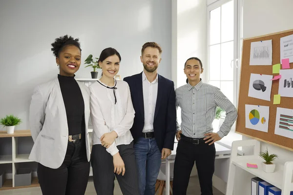 Équipe de gens d'affaires multiraciaux heureux debout dans le bureau de leur entreprise en démarrage — Photo