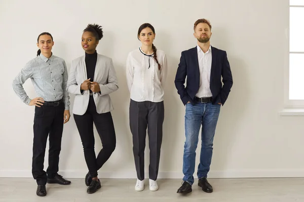 Grupp av multietniska företagsarbetare eller arbetssökande som står nära kontorsmuren — Stockfoto
