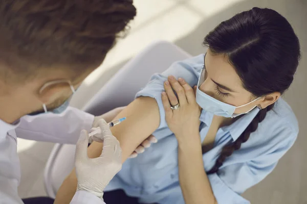 Woman in protective mask looking at doctor medical worker making vaccination injection — Stock Photo, Image