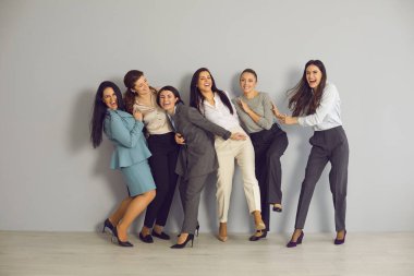 Heyecanlı genç iş kadınlarından oluşan bir takım birlikte eğleniyor ve başarıyı kutluyor.