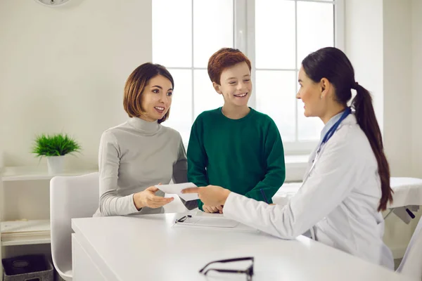 La doctora le da una receta para medicamentos a la madre de un niño.. —  Fotos de Stock