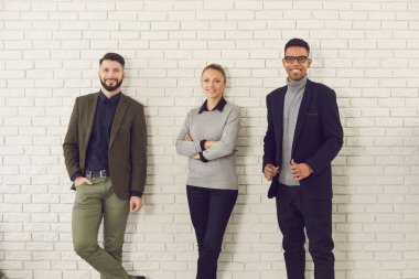 Bir grup gülümseyen genç meslektaşlar, şirket yöneticileri veya iş ortakları