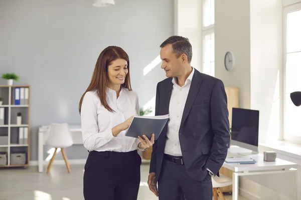 Smiling business people office workers standing and discussion project or report details together —  Fotos de Stock