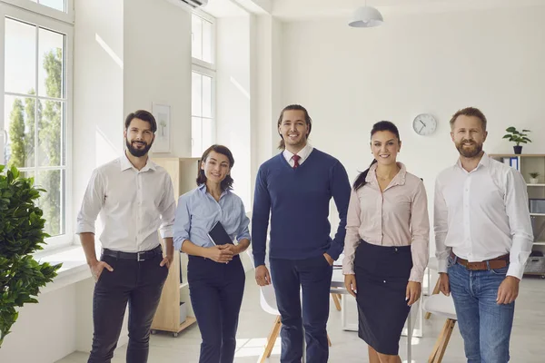 Succès souriants gens d'affaires collègues debout et regardant la caméra dans le bureau — Photo