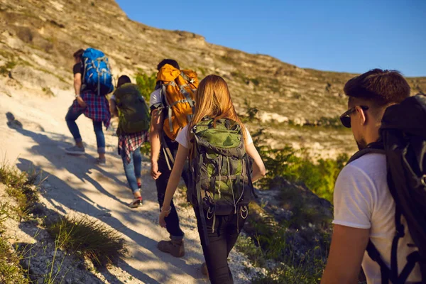 Grupo de jóvenes turistas excursionistas escalando la montaña durante las vacaciones de verano, vista trasera —  Fotos de Stock