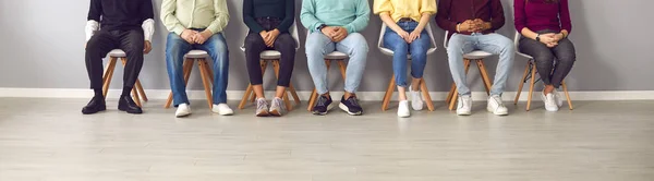 Cropped image of unrecognizable people sitting in the waiting room on chairs in line. — Stock Photo, Image