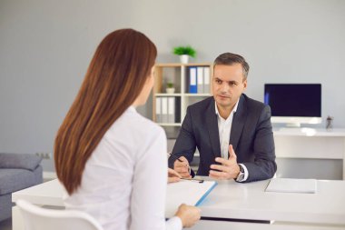 İnsan Kaynakları müdürü adayla görüşüyor, iş deneyimi ve iş koşulları hakkında sorular soruyor.