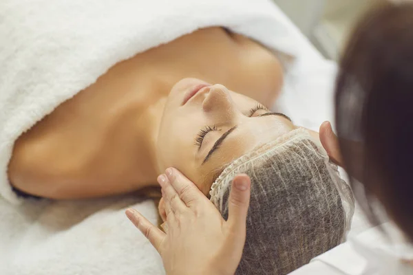 Massagem facial. Close-up de jovem mulher recebendo tratamento de massagem spa no salão de beleza spa. — Fotografia de Stock
