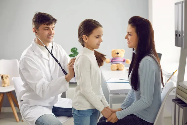 Hombre doctor pediatra examinar poco positivo chica paciente con estetoscopio —  Fotos de Stock