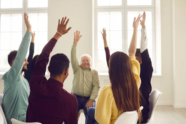 Group of happy people sitting in circle in community meeting and voting for good suggestion