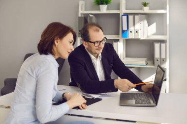 Emlakçı, müşterisine bilgisayar ekranında farklı ev varyantları gösteriyor.