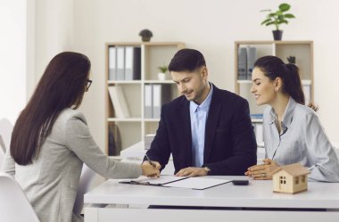 Mutlu çift ofiste yeni bir daire satın almak için sözleşme imzalıyor.