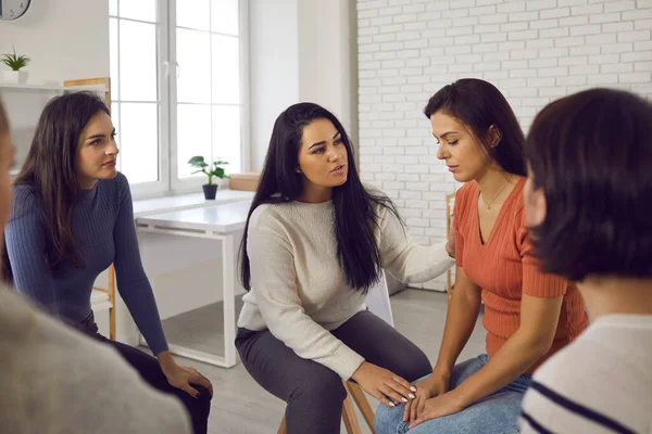 Mujeres en grupo de apoyo que reconfortan y ayudan a mujeres jóvenes que sufren de abuso emocional — Foto de Stock