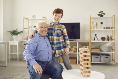 Mutlu gülümseyen yaşlı dede ve onun pozitif torunu kameraya bakarak evde sarılıyorlar.