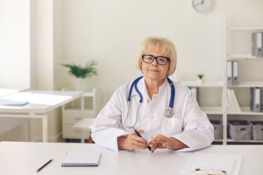 Kıdemli doktor hastalarına online danışmanlık hizmeti veriyor ve bir bilgisayar kamerası kullanarak iletişim kuruyor..