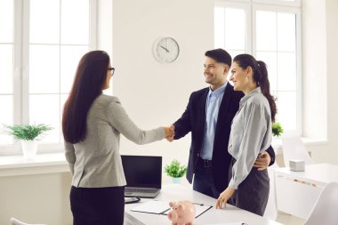 Mutlu aile ve banka temsilcisi veya danışman el sıkışması anlaşmayı onaylıyor.