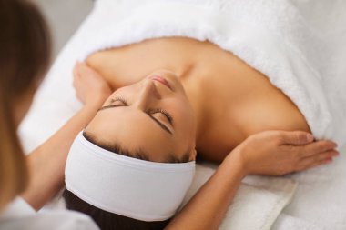 Kozmetik uzmanı ya da masör kadın için rahatlatıcı masaj yapıyor.