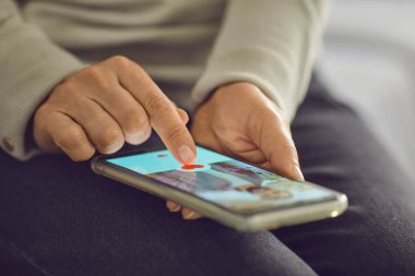 Randevu uygulamasında çekici erkeğin profil fotoğrafının altındaki benzer düğmeye basan bekar kadın.