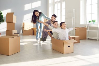 Karı koca ve çocukları karton bir kutuda oturmuş yeni evlerinde eğleniyorlar..