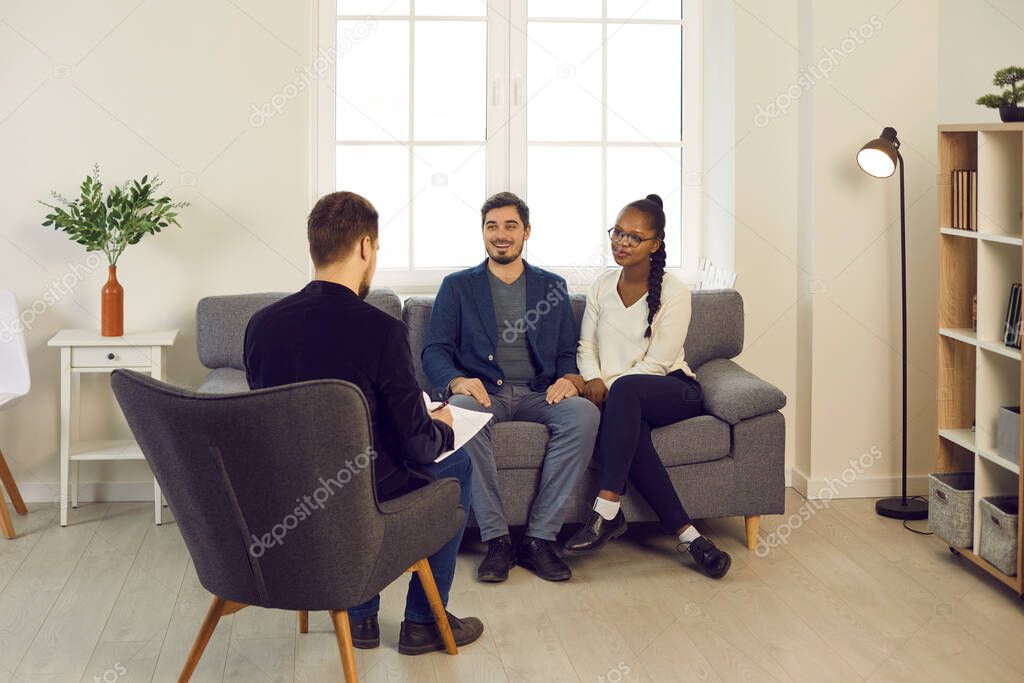 Pleased mixed race couple meeting family psychiatrist or financial advisor
