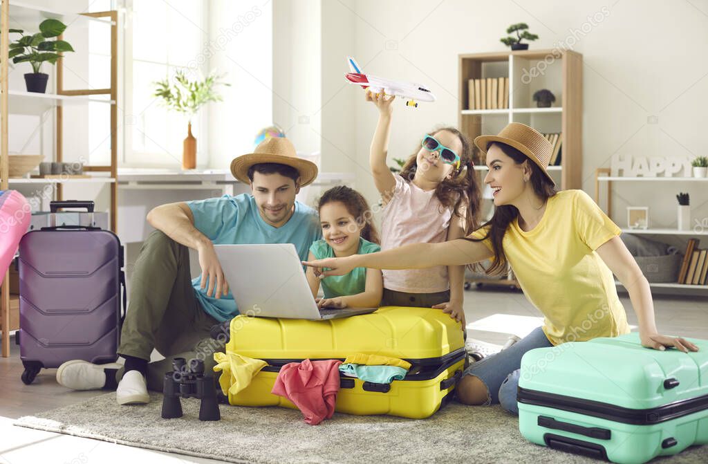 Happy family and kids with travel suitcase buying ticket booking hotel online