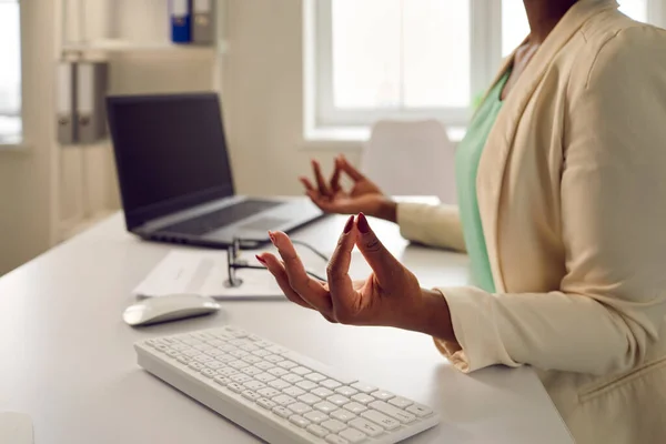 Mujer tranquila meditando y relajándose sentada en el escritorio de la oficina durante su día de trabajo — Foto de Stock