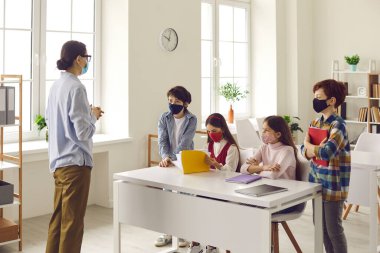 Öğretmenler öğretmenlik yapıyor. Sınıfta küçük bir grup, maskeli insanlar vuruluyor.