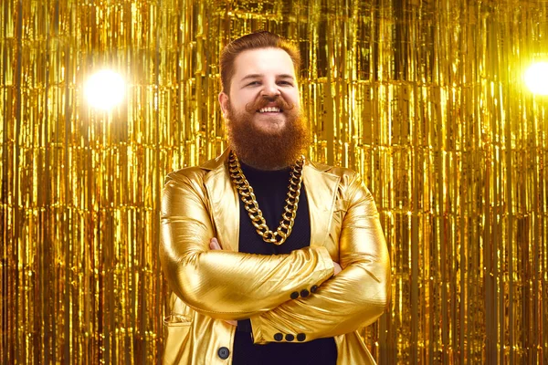Portrait of happy man in shiny golden disco jacket standing arms folded and smiling