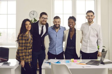 Pozitif gülümseyen çeşitli iş adamları ofis kameralarına sarılıyorlar.
