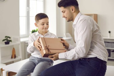 Mutlu küçük oğlan babasına doğum günü ya da Babalar Günü hediyesi veriyor.