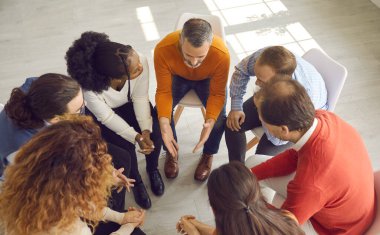 Çeşitli insanların terapi seanslarında ya da iş toplantılarında konuştuğu yüksek açılı bir çekim.