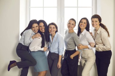 Ofis penceresinin önünde duran başarılı genç iş kadınlarının toplu portresi