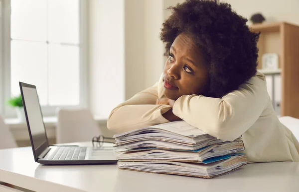 Young african american office worker dreaming leaning head on paper stack — Stock Photo, Image