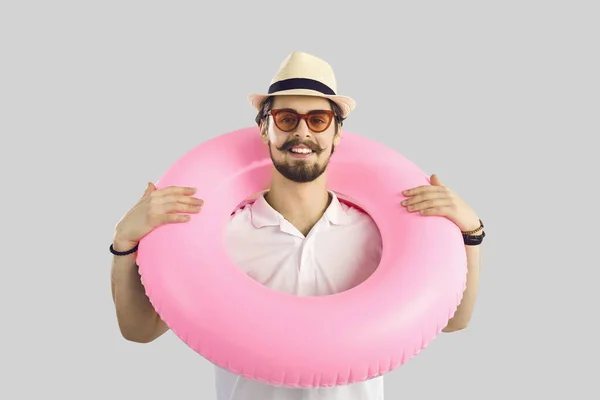 Portretul unui bărbat cu un cerc gonflabil roz în jurul gâtului, care este gata pentru vacanța de vară . — Fotografie, imagine de stoc