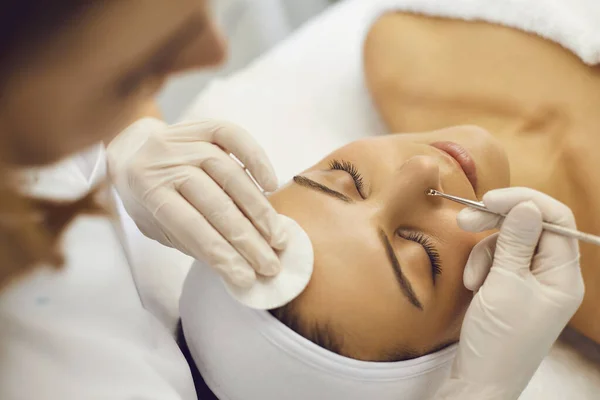 Cosmetician profissional removendo cravos no nariz dos clientes com a ajuda de ferramenta especial — Fotografia de Stock