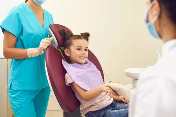 Uśmiechnięta dziewczyna uściska dłoń lekarzowi po udanym wyleczeniu w klinice stomatologicznej — Zdjęcie stockowe