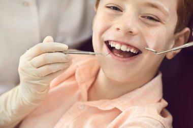 Diş muayenesi ve diş plağı sırasında küçük sevimli bir çocuğun portresini kapat..