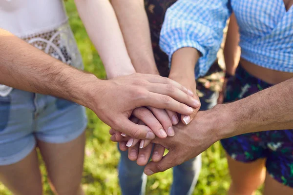 Unidade, parceria e cooperação. Grupo de pessoas irreconhecíveis colocando as mãos juntas ao ar livre, close-up — Fotografia de Stock
