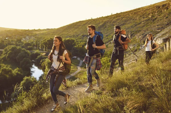 Groupe de touristes souriants randonneurs randonnée sur la nature avec sacs à dos avec vallée verte et rivière en arrière-plan — Photo