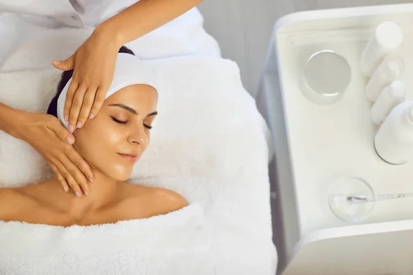Kosmetolog gör professionell manuell avkopplande föryngrande massage för ung kvinna — Stockfoto