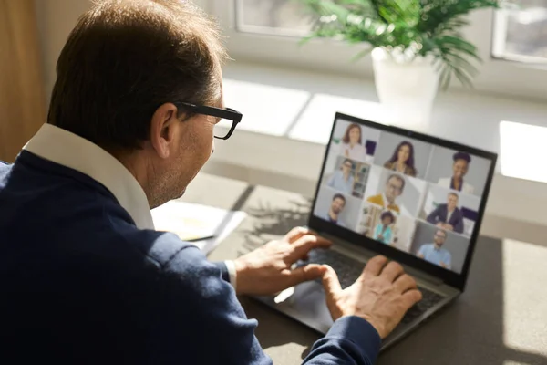 Senior man having virtual business meeting with team of employees and colleagues — Stock Photo, Image