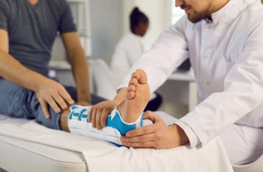 Bacağında bağ zedelenmesi olan bir hastaya tıbbi bakım sağlayan bir travmatoloğa yakın durun..