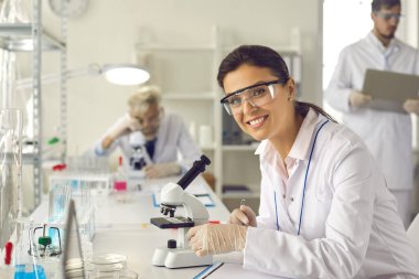 Modern bir araştırma laboratuvarında çalışan başarılı bir kadın bilim adamının portresi.