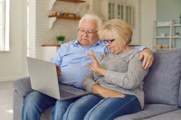 Anziani anziani coppia mani che salutano nipoti attraverso facetime utilizzando il computer portatile. — Foto Stock