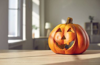 Cadılar Bayramı 'nın şenlikli arkaplanı ve masadaki sevimli gülümseyen Jack-O-Lantern.