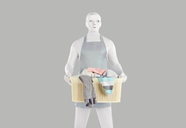 Man or home robot in bodysuit helps with housework and does laundry. Strange unusual man in white costume, mask and apron standing isolated on grey color background holding laundry basket with clothes